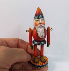 a hand is holding a small figurine in the shape of a santa clause