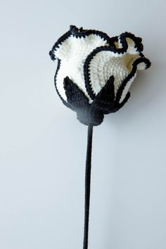 a black and white flower on a stick