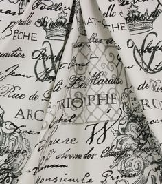 the fabric is white and has black writing on it, with a crown at the top