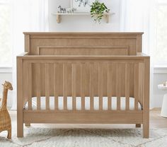 a baby crib in a room with white carpet and wooden furniture on the floor