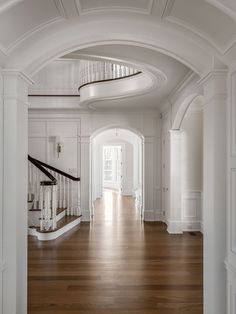 an archway leading to the second floor of a house with wood floors and white walls