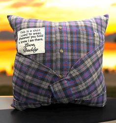 a pillow with a message on it sitting on a table in front of a sunset