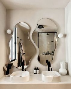 a bathroom with two sinks and mirrors on the wall