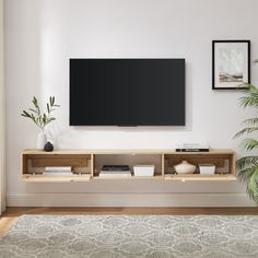 a flat screen tv mounted to the side of a white wall in a living room