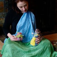 a woman sitting on the floor holding a stuffed animal