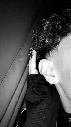 a man with curly hair is listening to music