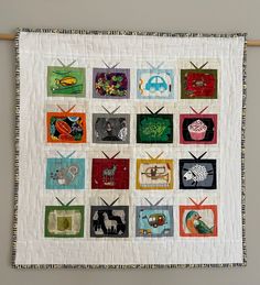 a quilted wall hanging with many different pictures on it