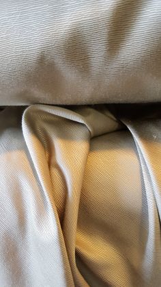 an up close shot of the fabric on a white bed sheet or comforter that has been folded over