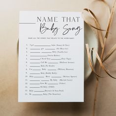 a name that baby song is on top of a white plate next to a brown ribbon