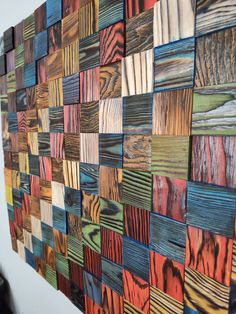 a wall made out of wooden planks with different colors and patterns on it's sides