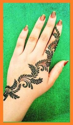 a woman's hand with black henna tattoo on her left hand and green background