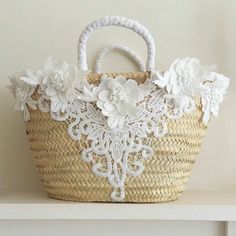 a basket with white flowers on it sitting on a shelf