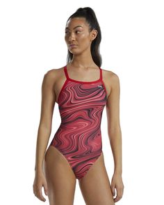 a woman in a red and black one piece swimsuit with an abstract design on the side