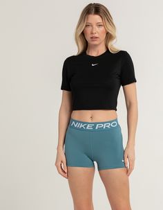 a woman in black shirt and teal shorts with nike pro logo on the side