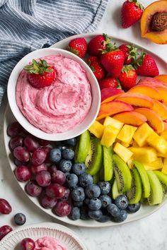 a white plate topped with fruit and dip