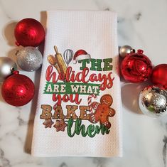 the holidays are what you bake them dish towel is next to christmas ornaments and balls