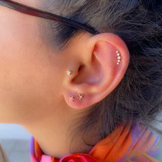 a close up of a person wearing a pair of ear piercings on their ears