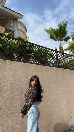 a woman standing in front of a wall