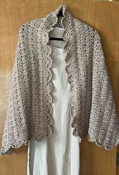 This Shawl is handmade by me and is new. The Measurements are 60 long and 22 wide.   . It has the most beautiful shell stitch. The edging is made up with lacy shells. It is made from 100 % acrylic yarn. The yarn is very soft and silky to the feel.  The color of this shawl is called Cappuccino which is a light Beige.  It can be worn with just about any color.  Perfect when you want to dress up a Dress or even wear over a top with jeans or dress pants  It would make a beautiful Wedding Shawl, For them cooler nights to put something like this around your shoulders would be great and not only that but beautiful looking too. For the cooler days and nights coming, this would be a great thing to have. The shawl can be washed in the washer in cold water on delicate and I would lay flat to dry, or Dress Up A Dress, Shawl Wedding, Beige Crochet, White Shawl, Evening Shawls, Black Shawl, Crochet Shawls And Wraps, Shell Stitch, Crochet Shawls