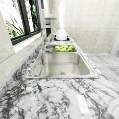 a kitchen with marble counter tops and stainless steel sink faucet in the middle