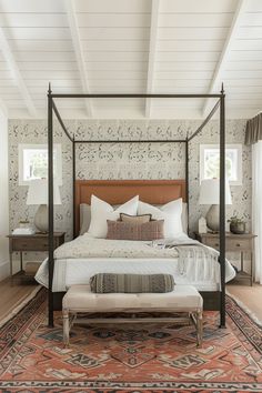 a bedroom with a four poster bed and an ottoman