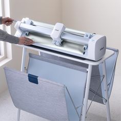 a person is using a large machine to cut paper