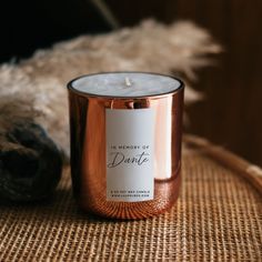 a candle sitting on top of a wicker table next to a stuffed animal and some fur