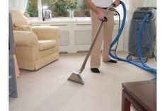 a man vacuuming the carpet in his living room