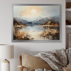 a painting hanging on the wall above a couch in a room with pillows and lamps