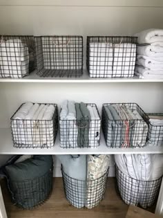 baskets and blankets are stacked on shelves in the closet