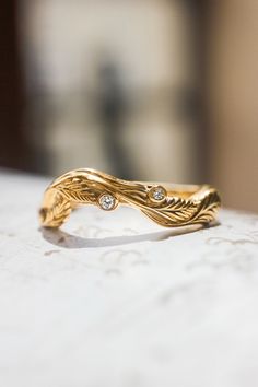 a close up of a gold ring with diamonds on it's side, sitting on a table