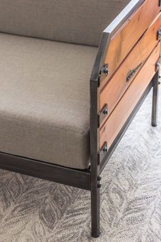 a couch with wooden slats and metal arms on carpeted flooring in a room