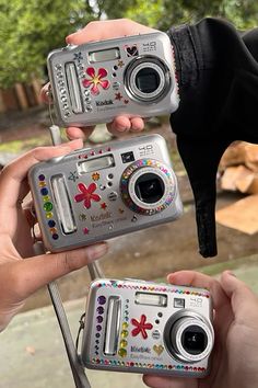 two people holding up cameras in their hands