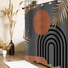 a shower curtain with an abstract design and palm leaves on the outside, along with a white rug