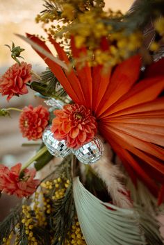 a vase filled with flowers and feathers on top of a table