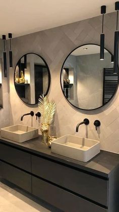 a bathroom with two sinks and mirrors on the wall