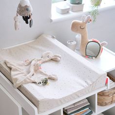 a baby's crib with stuffed animals and toys on the table next to it