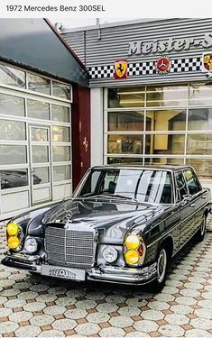 a mercedes benz 300sel parked in front of a building with checkered flooring