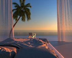 a bed sitting under two tall curtains next to a palm tree