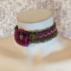 Handmade Jewel Tone Rosette Plum And Olive Green Chiffon & Velvet Choker This Necklace Was Hand Made By Me And Features A Lace Flower Crafted Using Purply Plum Toned Ribbon Chiffon With Clear And A Mixture Of Clear/Silver Seedbeads And Metallic Green Seed Beads In The Center. The Rosette Rests On Top Of Olive Green Velvet Which Features Metallic Gold Embroidery Stitches To Give The Leaves Detail. The Same Plum Toned Chiffon Ribbon Is Machine-Sewn Over Decoratively Frayed Edged Olive Green Velvet Using A Decorative Stitch In A Gold Tone To Give Dimension And Then Adorned With Hand-Sewn Seed Beads To Add Sparkle. Finished With Gold Finishings. Clasps In Back, And Has A Gold Chain For Easy Fit Elegant Adjustable Green Choker, Handmade Victorian Green Necklaces, Green Velvet Choker, Green Adjustable Vintage Choker, Vintage Purple Choker Necklace, Velvet Necklace, Velvet Choker, Handmade Jewel, Gold Embroidery