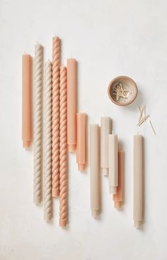 an assortment of orange and white straws next to a button on a white surface