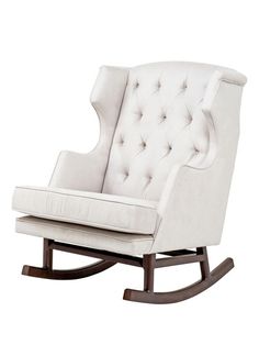 a white rocking chair with buttons on the back and seat upholstered to it