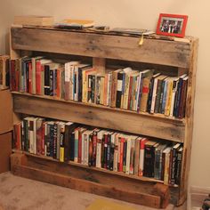 a bookshelf made out of pallet wood with lots of books on top