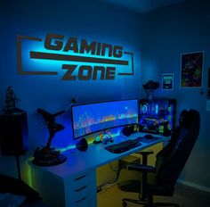 a computer desk with two monitors and a keyboard on it in front of a gaming zone sign