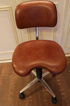 a brown office chair sitting on top of a hard wood floor