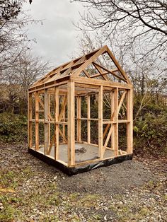 a small wooden structure sitting in the middle of a field