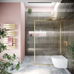 a modern bathroom with pink walls and gold trim around the bathtub, toilet and shower