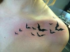 a group of bats flying in the sky on a woman's chest tattoo design