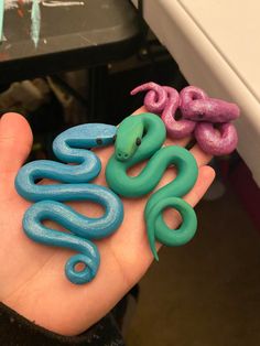 a person's hand holding some fake snakes in their palm and the word boo spelled out