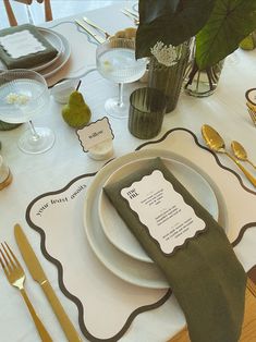 a table set with place settings, silverware and napkins for an elegant dinner